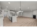 Open concept kitchen with island, stainless steel appliances, and hardwood floors at 4996 Hummingbird Dr, Brownsburg, IN 46112
