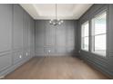 Bright dining room with gray wainscoting, hardwood floors, and a modern chandelier at 1433 Chatham Hills Blvd, Westfield, IN 46074