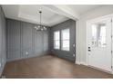 Elegant entryway with dark gray paneled walls, hardwood floors, and modern lighting at 1433 Chatham Hills Blvd, Westfield, IN 46074