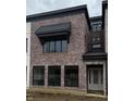 Modern brick townhouse exterior with a metal roof and large windows at 11896 Spring Mill Rd, Carmel, IN 46032