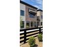 Modern brick townhome with black window trim, and a dark wooden fence bordering the front yard at 11896 Spring Mill Rd, Carmel, IN 46032