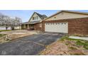 View of brick home featuring a long driveway leading to an attached garage at 232 N Church St, Morgantown, IN 46160