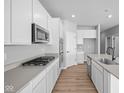 Modern kitchen with stainless steel appliances and sleek white cabinets at 3537 Wrangler Dr, Bargersville, IN 46106