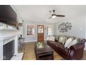 Cozy living room with hardwood floors, a decorative fireplace, and many windows at 5890 Kingsley Dr, Indianapolis, IN 46220