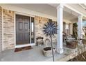 Charming front porch with decorative windmill, inviting seating, and stylish brick accents at 719 Trent Dr, Greenwood, IN 46143