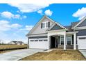 Beautiful home boasting a white garage door, blue siding, and a covered front porch at 413 Onset Way, Westfield, IN 46074