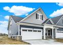 Side view of a stylish home with a white garage door, blue siding, and gray shingle accents at 413 Onset Way, Westfield, IN 46074