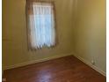 Bedroom featuring hardwood floors, green walls, and a window with curtains at 3305 N Keystone Ave, Indianapolis, IN 46218