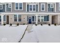 Townhome entrance with a covered porch, brick facade, and landscaping at 5759 Cr W 750 N, McCordsville, IN 46055