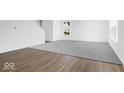 Open living room featuring a seamless blend of wood flooring and new carpeting at 475 Chester Ln, Pittsboro, IN 46167