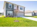 A two-story home with a lush green lawn, a spacious driveway, and a well-maintained exterior at 1217 Fleming Dr, Greenfield, IN 46140