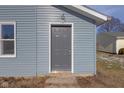 Gray front door adds to the curb appeal of this renovated home at 405 E 9Th St, Sheridan, IN 46069