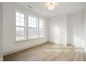 Bright, open room featuring gleaming hardwood floors and large windows that flood the space with natural light at 12001 Gia Ct, Noblesville, IN 46060