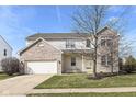 Charming two-story home featuring brick accents, a two-car garage, and a well-maintained lawn at 12912 Broncos Dr, Fishers, IN 46037