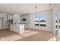 Modern kitchen with white cabinets, island, and stainless steel appliances at 5034 Bergamot Dr, Brownsburg, IN 46112