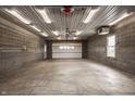 Spacious garage with concrete floor, block walls, overhead lighting, and door to the exterior at 5861 S 100 W, Fountaintown, IN 46130