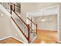 Welcoming entryway with hardwood floors and a staircase featuring wood railings and carpeted steps at 6640 Greenridge Dr, Indianapolis, IN 46278