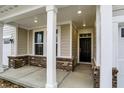 Welcoming covered porch with brick accents and white columns, providing a cozy and inviting entrance to the home at 18415 Depoe Ln, Westfield, IN 46074