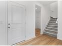 Bright foyer featuring a white front door, luxury vinyl floors, and a carpeted staircase at 251 Hunters Ridge Dr, Danville, IN 46122