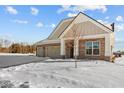 Brick ranch home with 2-car garage, snowy front yard, and charming architectural details at 5021 Carmine St, Brownsburg, IN 46112