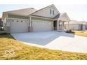 An inviting exterior view of a home with a spacious driveway and three-car garage, nestled in a peaceful neighborhood at 245 Lar Lan Dr, Danville, IN 46122