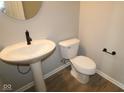 Powder room with pedestal sink, toilet, and modern fixtures at 16990 Silo Ridge Way, Noblesville, IN 46060