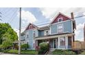 Charming blue house with red trim, well-maintained landscaping, and a cozy front porch at 2036 N Talbott St, Indianapolis, IN 46202