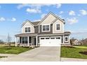 Stylish gray two-story home with a covered front porch, two-car garage, and manicured lawn and landscaping at 4180 Bozeman Way, Bargersville, IN 46106