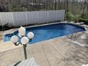 A sparkling in-ground pool is surrounded by a concrete patio and a privacy fence at 6902 Creekridge Trl, Indianapolis, IN 46256