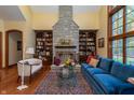 Bright living room with a stone fireplace flanked by bookcases, comfortable seating and wood floors at 7258 N Richardson Dr, Morgantown, IN 46160