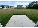 Small concrete patio in a backyard with green grass and houses in the background at 1191 Taggart Way, Greenwood, IN 46143