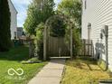 Enchanting side yard with a decorative archway that leads to a garden area and walkway at 534 Austrian Way, Avon, IN 46123