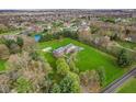 Aerial view of an estate surrounded by lush greenery, mature trees, and nearby ponds in a tranquil neighborhood at 5911 N 400 W, Bargersville, IN 46106
