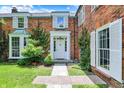 Close-up of the front entrance with a classic white door, decorative pillars, and manicured landscaping at 2505 Riverside Dr, Columbus, IN 47201