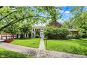 Beautiful brick home featuring a manicured lawn, mature trees, and a stone walkway to the front entrance at 2505 Riverside Dr, Columbus, IN 47201