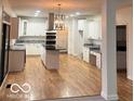 Open kitchen with white cabinets, stainless steel appliances, and a center island at 6362 Harmonridge Ct, Indianapolis, IN 46278