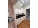 Charming kitchenette with custom white cabinets, granite countertops, and wooden floors at 6362 Harmonridge Ct, Indianapolis, IN 46278