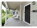 Inviting covered front porch with chairs, a black front door, and a secure keypad at 1709 Hoyt Ave, Indianapolis, IN 46203