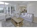 Bright living room features neutral decor, and a view into the kitchen area with white cabinets and stainless appliances at 2639 Collins Dr, Westfield, IN 46074