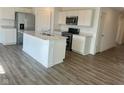 Bright kitchen with an island, stainless steel appliances, white cabinets, and a view to a spacious dining area at 6629 Sulgrove Pl, Indianapolis, IN 46221