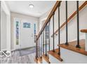 Bright entryway featuring stylish floors, stairs with metal spindles, and a view of the front door at 839 Fernwood Ct, Indianapolis, IN 46234