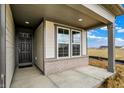 Welcoming front porch with brick accents, large windows, a gray door, and views of the neighborhood at 18322 Depoe Ln, Westfield, IN 46074