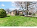 Well-maintained brick home with manicured lawn and mature landscaping in a quiet neighborhood at 8528 Quail Hollow Rd, Indianapolis, IN 46260