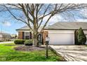 Charming brick home featuring an attached two-car garage and manicured landscaping at 8528 Quail Hollow Rd, Indianapolis, IN 46260