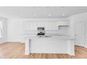 Open concept kitchen featuring white cabinetry, marble countertops, and a large center island at 1095 Bevy Blvd, Danville, IN 46122