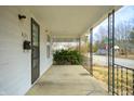 View from covered porch featuring concrete flooring, metal railing and views of the street at 825 Arrow Ave, Anderson, IN 46016