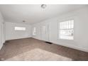 Bright living room with carpet floors, neutral walls, and natural light from multiple windows at 825 Arrow Ave, Anderson, IN 46016