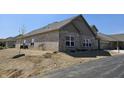 New brick home with a side view showing large windows, landscaped yard and paved driveway in a nice neighborhood at 2331 Saddle Dr, Shelbyville, IN 46176