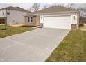 New home featuring a long concrete driveway, attached garage, and a freshly sodded front lawn at 6112 Card Blvd, Indianapolis, IN 46221
