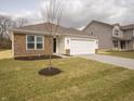 Attractive single-Gathering home with stone detailing, a pristine lawn, and an attached two-car garage at 6112 Card Blvd, Indianapolis, IN 46221